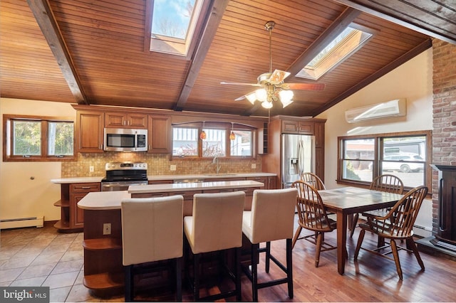 kitchen with vaulted ceiling with skylight, a center island, stainless steel appliances, and a wealth of natural light