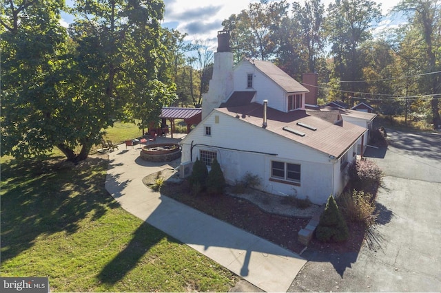 29 Boulder Rd, Upper Black Eddy, PA 18972 - view of side of home featuring a fire pit, a chimney, and a lawn
