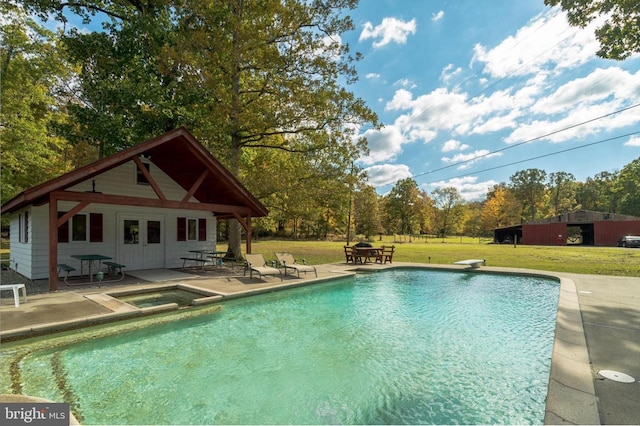 view of pool with an in ground hot tub, a yard, a diving board, and a patio area