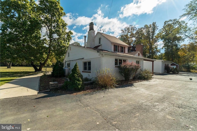 29 Boulder Rd, Upper Black Eddy, PA 18972 - view of side of property with a chimney, driveway, and stucco siding