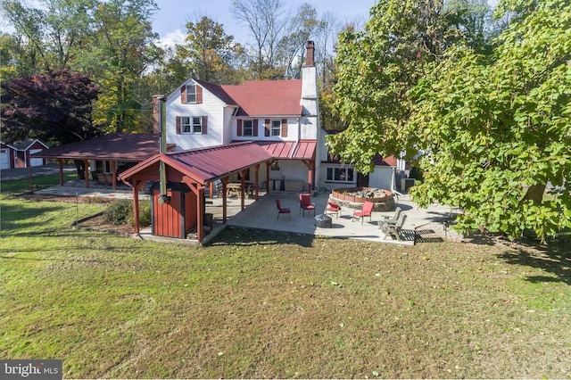 back of house featuring a patio, an outdoor fire pit, and a lawn