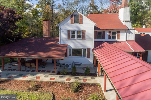 29 Boulder Rd, Upper Black Eddy, PA 18972 - back of house featuring a patio area, metal roof, a chimney, ac unit, and a standing seam roof