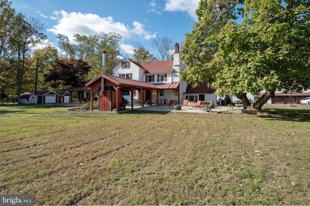 29 Boulder Rd, Upper Black Eddy, PA 18972 - rear view of property featuring a yard, a chimney, a standing seam roof, metal roof, and a patio area
