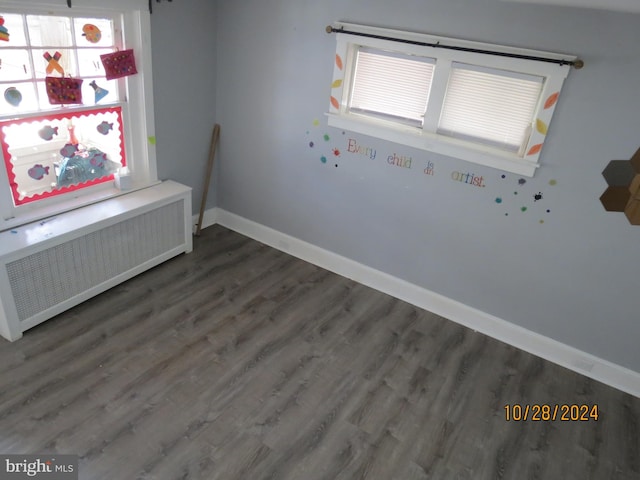 interior space with dark wood-type flooring and radiator