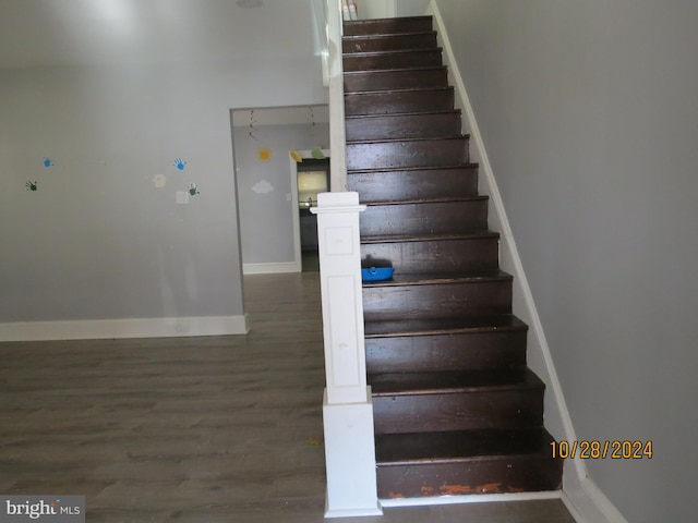 staircase with hardwood / wood-style floors