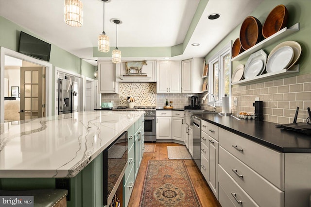 kitchen featuring stainless steel appliances, hardwood / wood-style flooring, dark stone counters, a spacious island, and white cabinets