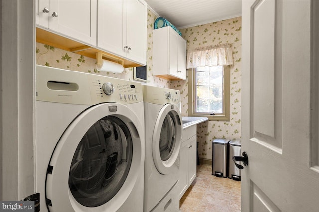 laundry room with washing machine and clothes dryer, cabinets, and light tile patterned floors