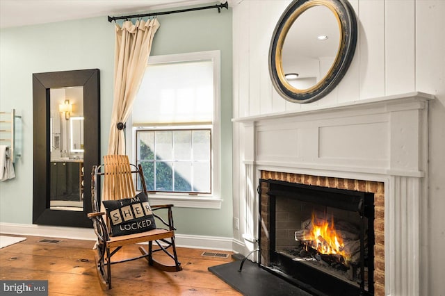 sitting room with a fireplace and hardwood / wood-style floors