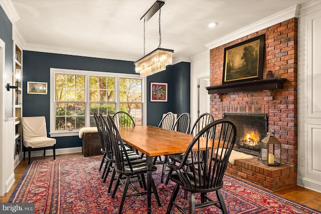 dining area with a fireplace, hardwood / wood-style flooring, and crown molding