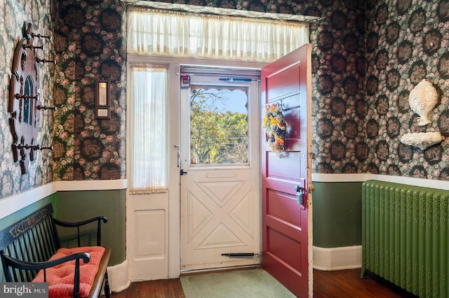 doorway to outside with radiator and dark hardwood / wood-style floors