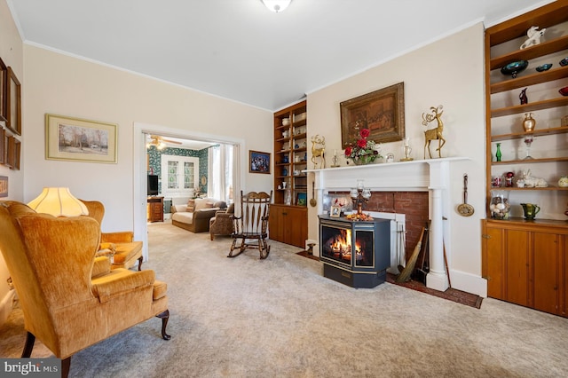 sitting room featuring crown molding, light colored carpet, built in features, and a fireplace