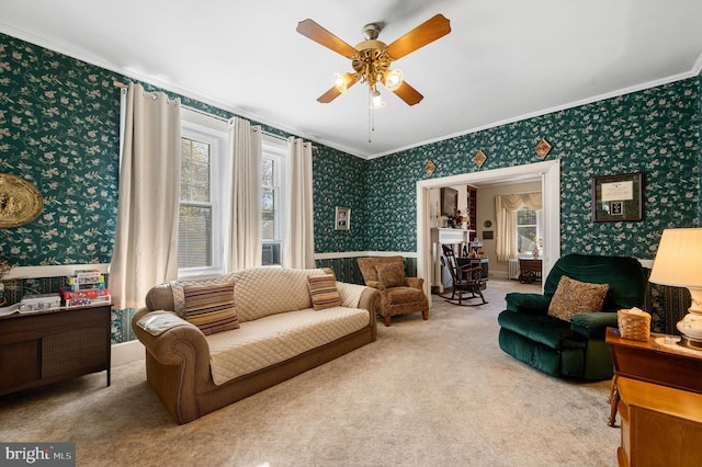 carpeted living room with crown molding and ceiling fan