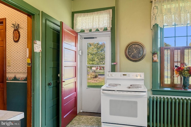 kitchen with plenty of natural light, radiator heating unit, and electric range