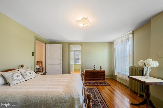 bedroom featuring radiator and hardwood / wood-style floors