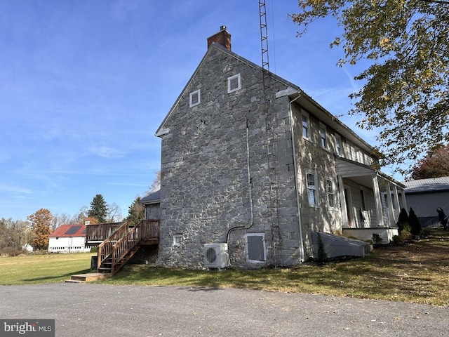 view of home's exterior with ac unit, a wooden deck, and a yard