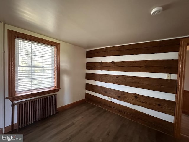 unfurnished room featuring dark hardwood / wood-style flooring and radiator