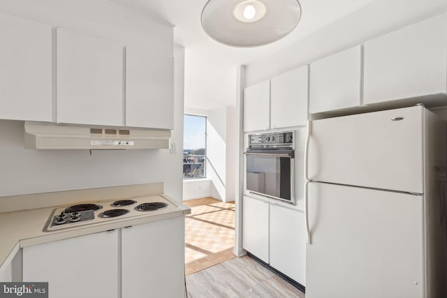 kitchen with white cabinets, light hardwood / wood-style floors, and white appliances