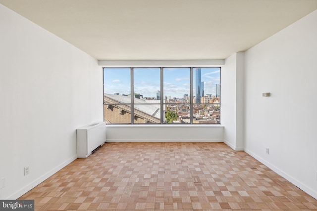 empty room with radiator heating unit and light parquet floors