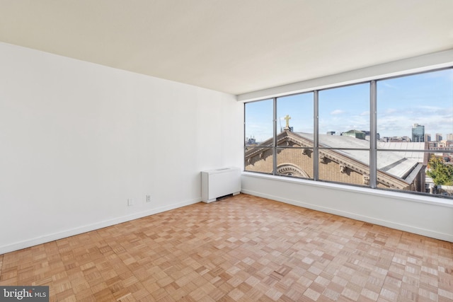 empty room featuring light parquet flooring and radiator heating unit