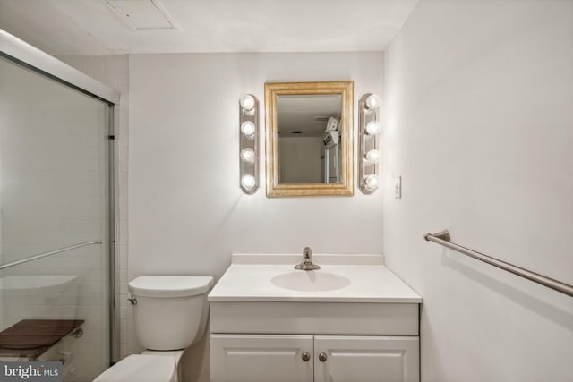 bathroom featuring a shower with shower door, vanity, and toilet