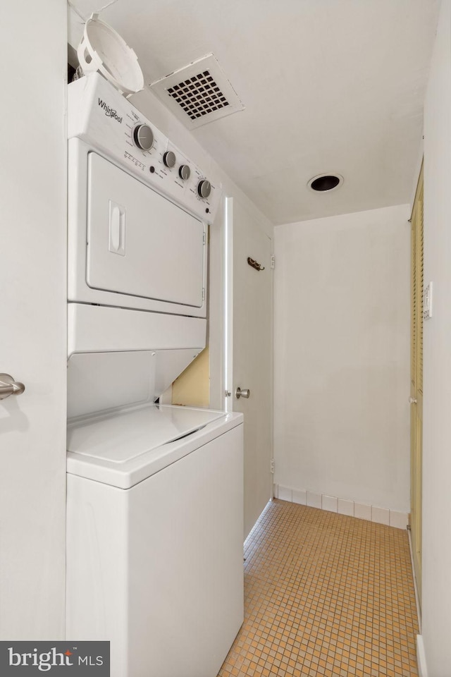 washroom featuring light tile patterned floors and stacked washer / dryer