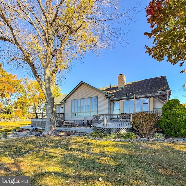 back of property featuring a lawn and a wooden deck