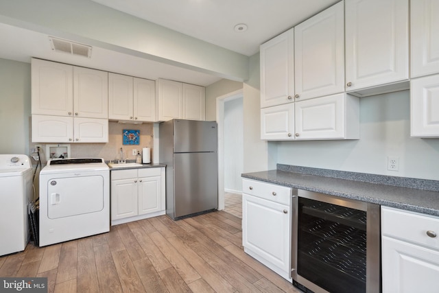 kitchen featuring stainless steel refrigerator, white cabinetry, and wine cooler