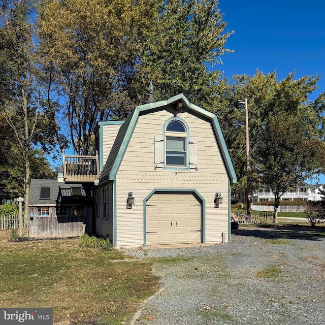 view of side of property with a garage, a yard, and a balcony