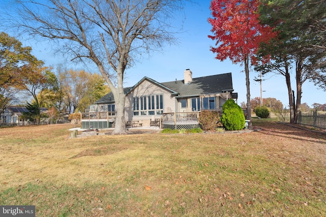 back of house with a lawn and a deck