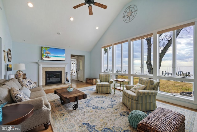 living room with high vaulted ceiling, plenty of natural light, hardwood / wood-style flooring, and ceiling fan