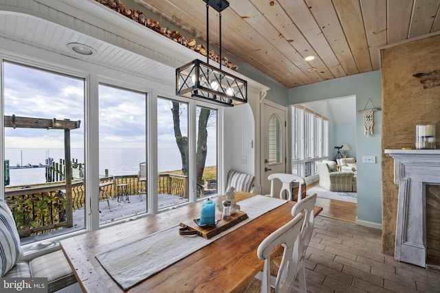 dining space with wooden ceiling, wood-type flooring, a healthy amount of sunlight, and a water view