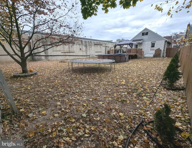 view of yard featuring a trampoline and a deck