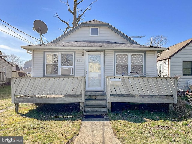 bungalow-style house with a front lawn and a wooden deck