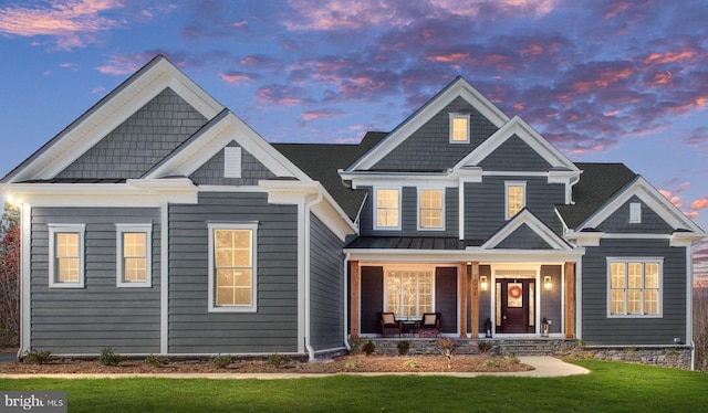 craftsman inspired home featuring a porch and a lawn