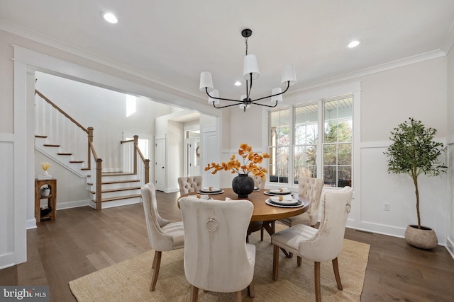 dining room with dark wood-type flooring, an inviting chandelier, and ornamental molding