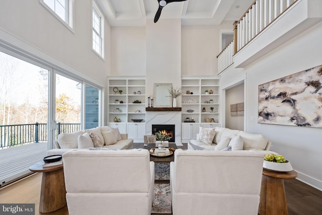 living room with hardwood / wood-style floors, a high ceiling, and ceiling fan