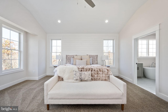 carpeted bedroom featuring lofted ceiling, ceiling fan, and ensuite bath