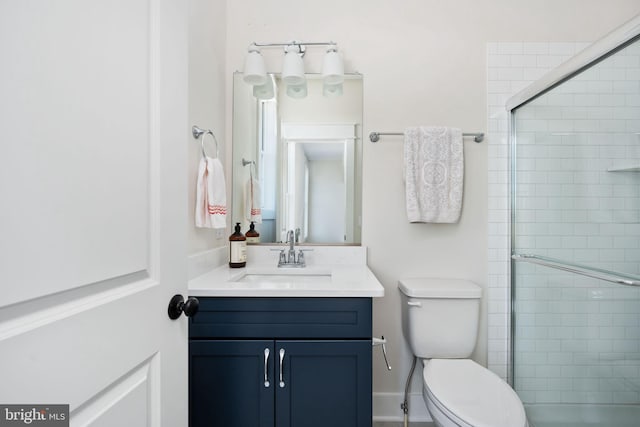 bathroom featuring toilet, an enclosed shower, and vanity