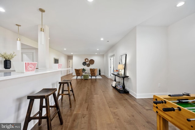 kitchen with pendant lighting, hardwood / wood-style floors, and a kitchen bar