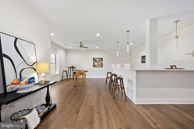 kitchen featuring pendant lighting, hardwood / wood-style flooring, and a breakfast bar area