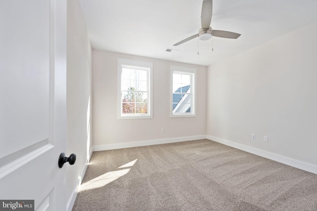 empty room with ceiling fan and light colored carpet