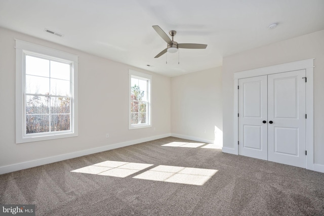 unfurnished bedroom featuring carpet floors, ceiling fan, and a closet