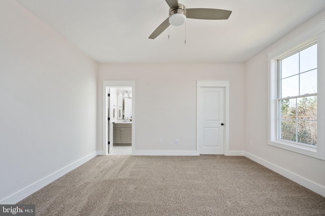 unfurnished bedroom with light colored carpet, ceiling fan, and ensuite bath