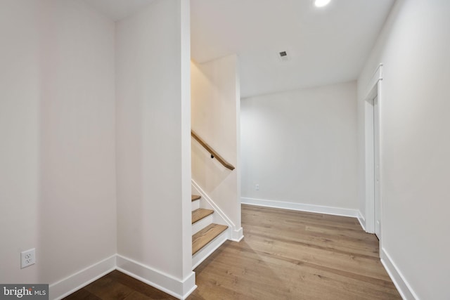 staircase with hardwood / wood-style floors