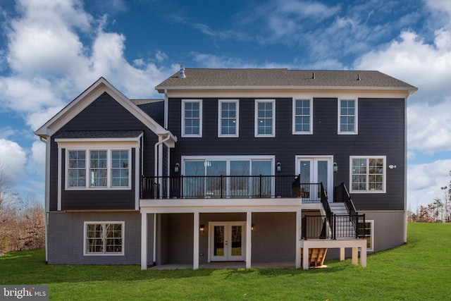 back of property featuring a deck, a yard, and french doors