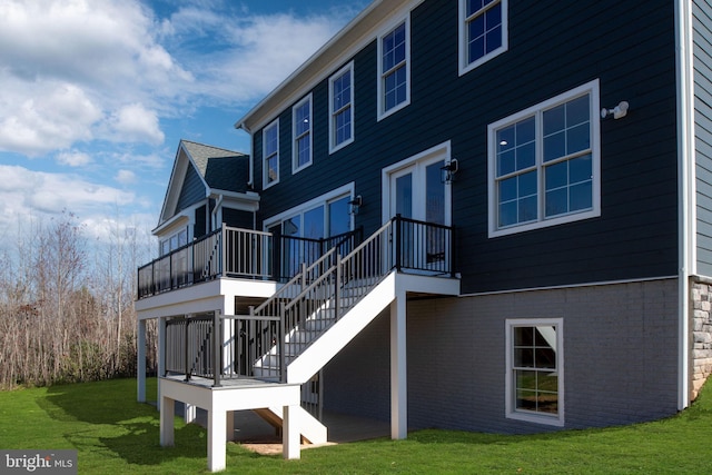 rear view of house with a wooden deck and a yard