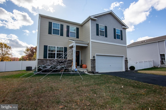 view of front of home with a front lawn, central AC unit, and a garage