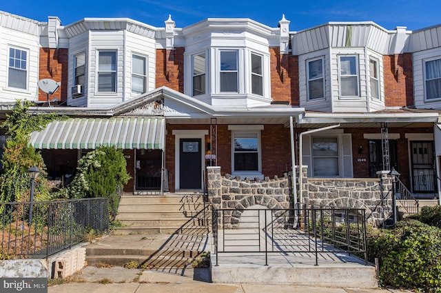 townhome / multi-family property featuring covered porch