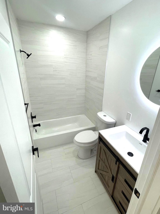 full bathroom featuring vanity, tiled shower / bath combo, and toilet