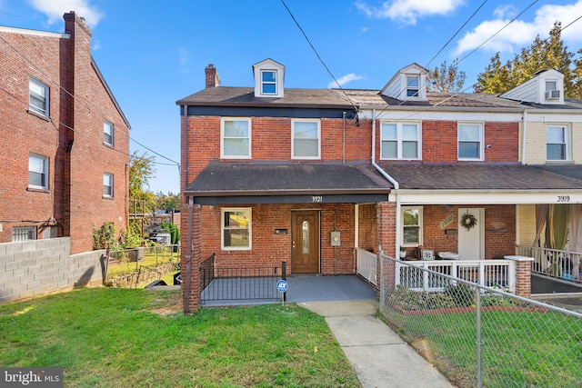 multi unit property with a front yard and a porch